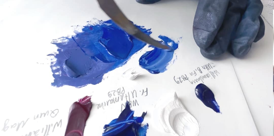 Several colors of paint being mixed together in an attempt to create YInMn Blue Hue