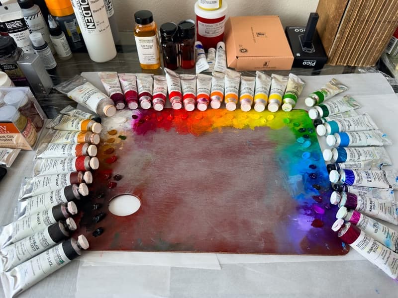 An artist palette surrounded by tubes of paint.