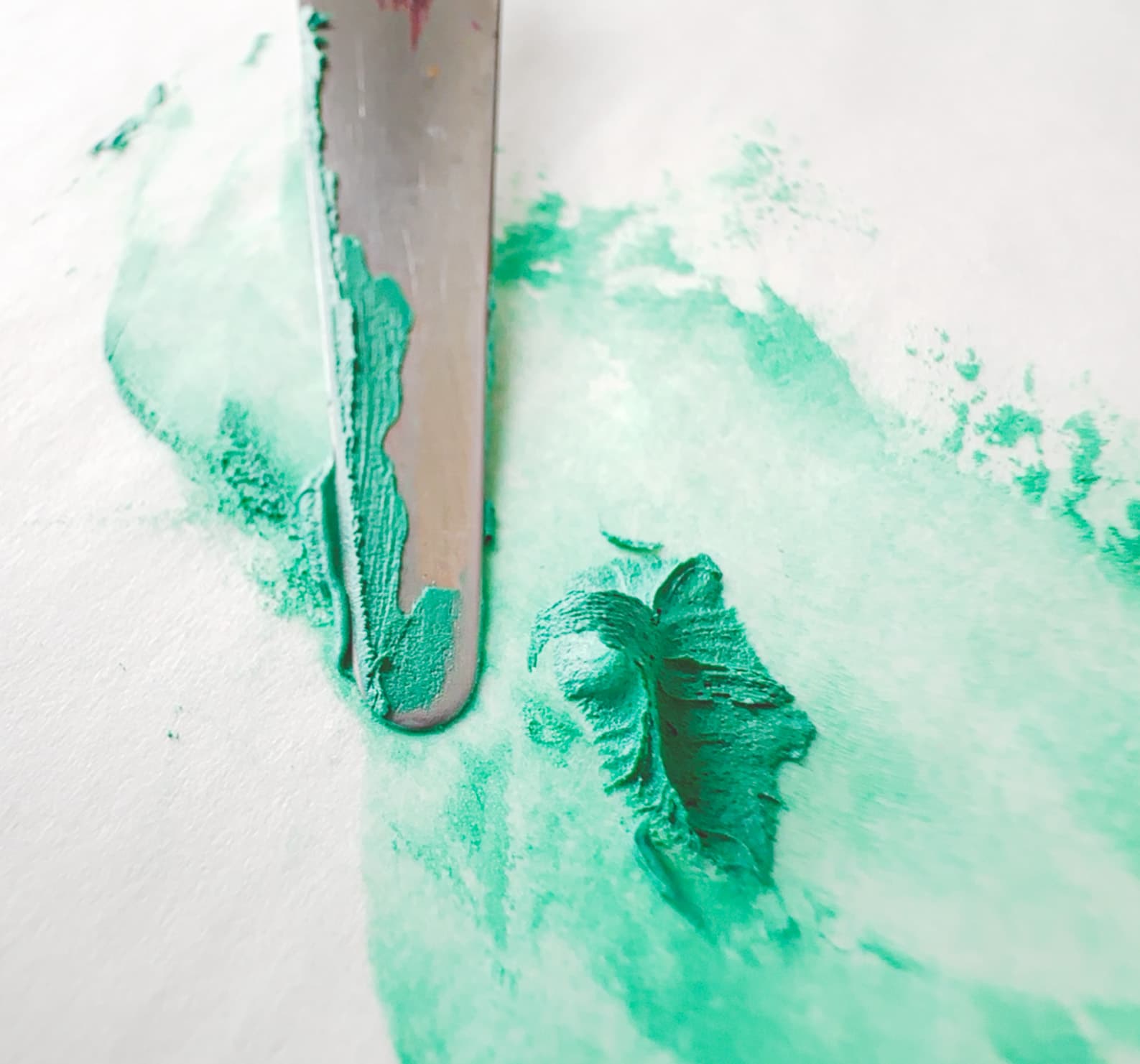 A daub of oil paint forms a peak when pulled up with a palette knife