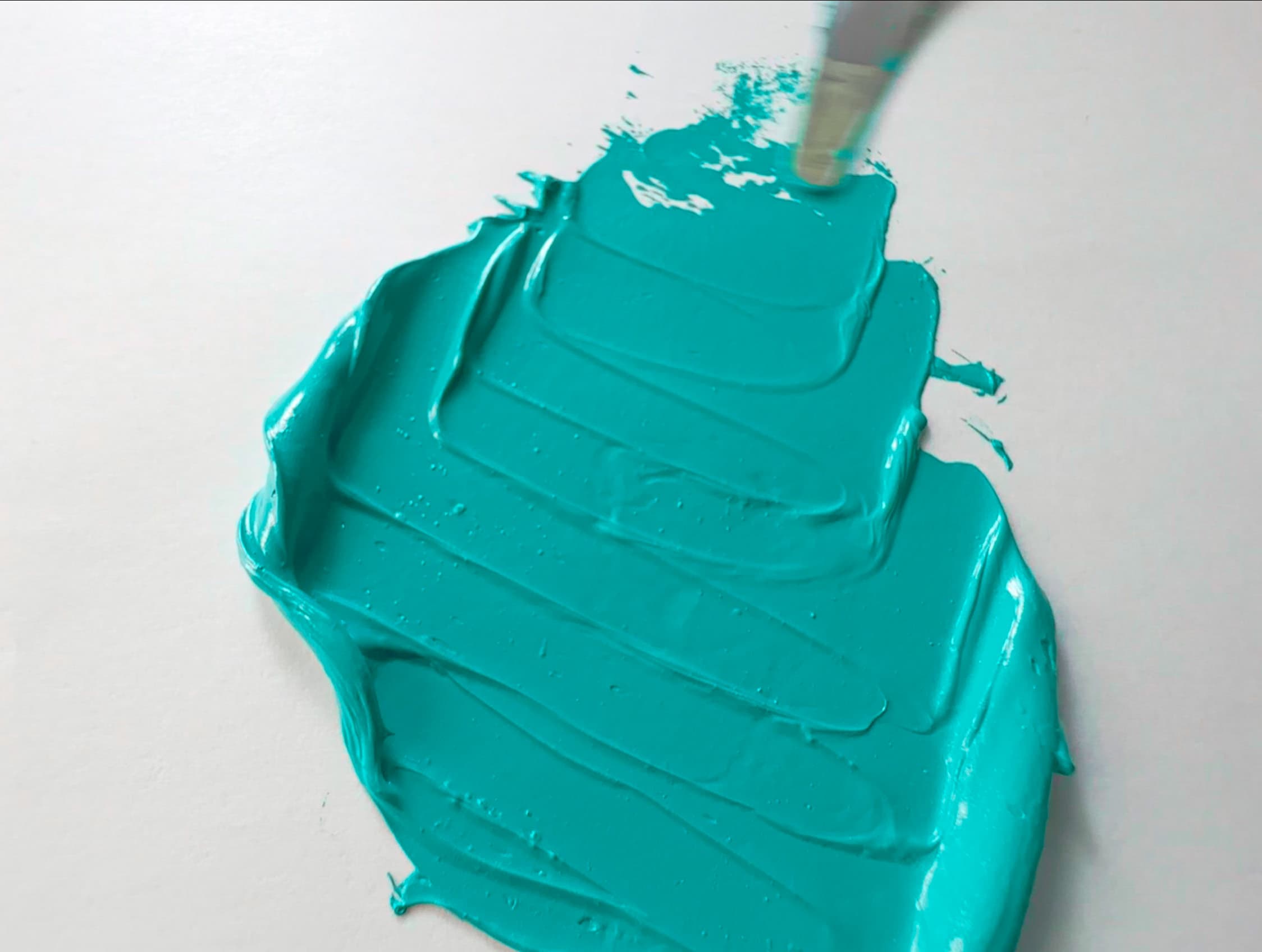 A swatch of teal oil paint pulled with a palette knife. The teal is made with pigment PG50