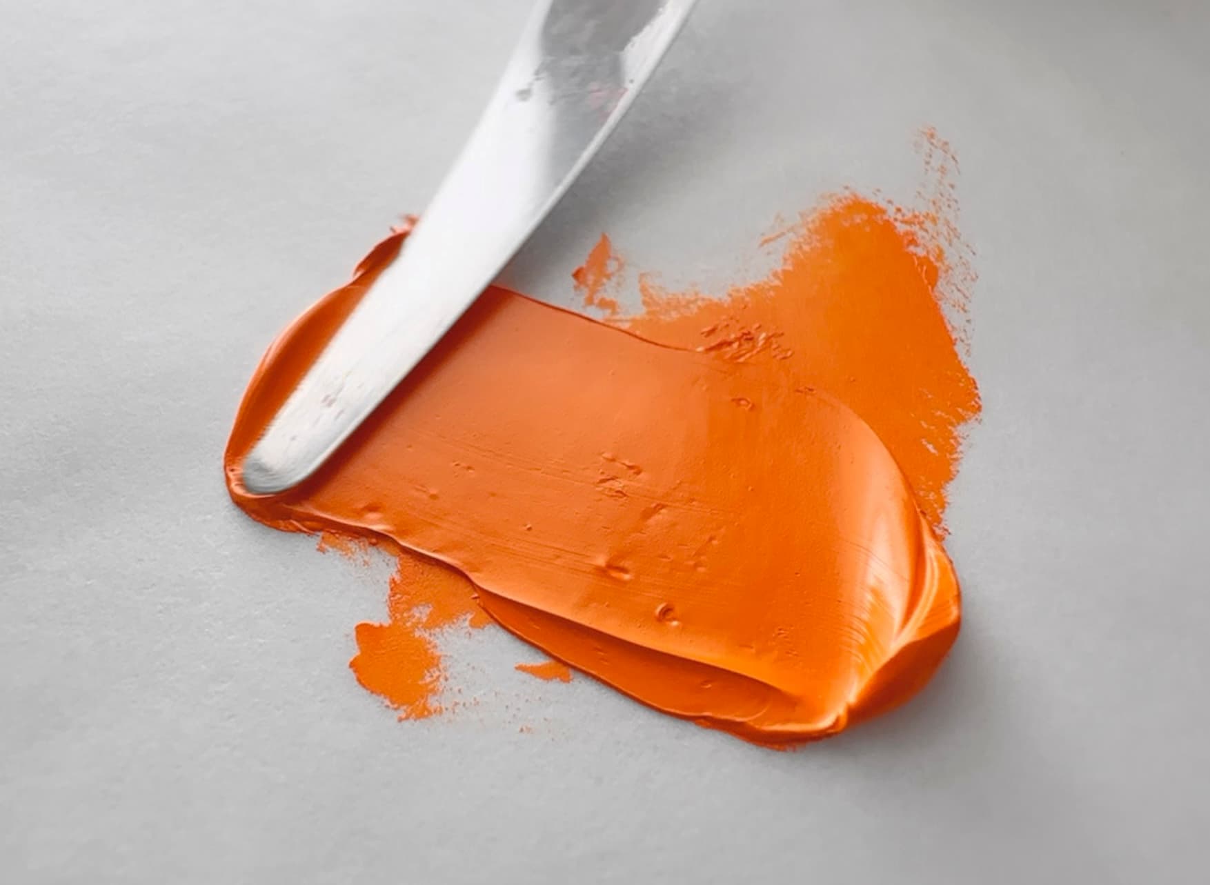 An impasto stroke of paint made with Cadmium Orange pigment
