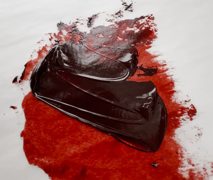 A rich sweep of dark Quinacridone Burnt Scarlet paint that also shows a glowing red-brown glaze when spread thinly