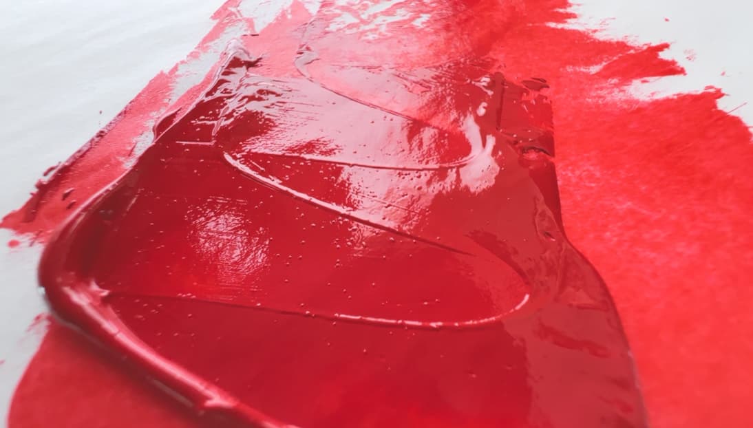 Swoosh of bright red oil paint made of Quinacridone Scarlet, also known as Quinacridone Red Light