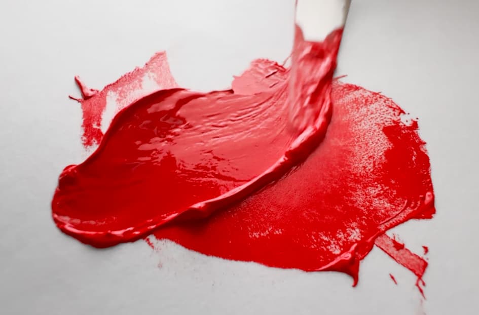 A bright red-orange daub of oil paint made with Pyrrole Red by Vasari