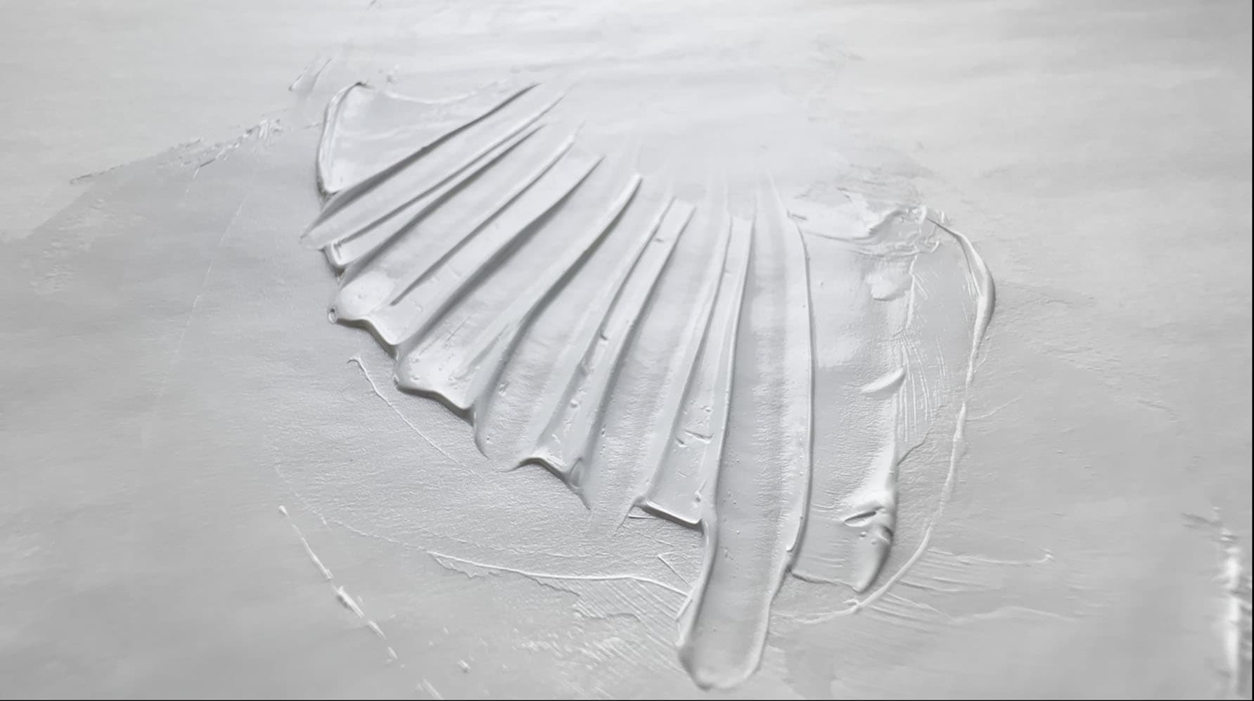 An impasto swatch of Permalba White oil paint with troughs made by a palette knife drawn through it