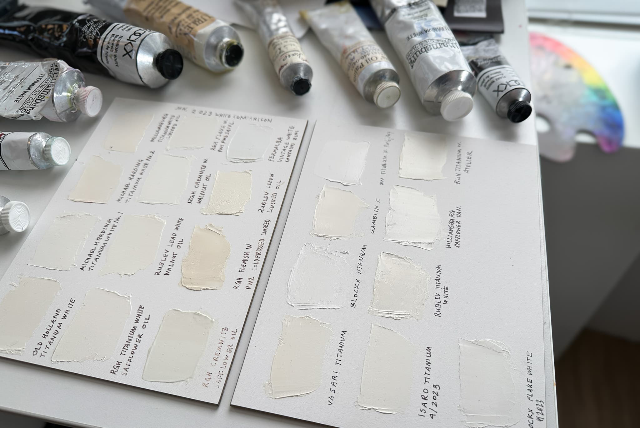A panel with swatches of dried oil paint which have yellowed to varying degrees