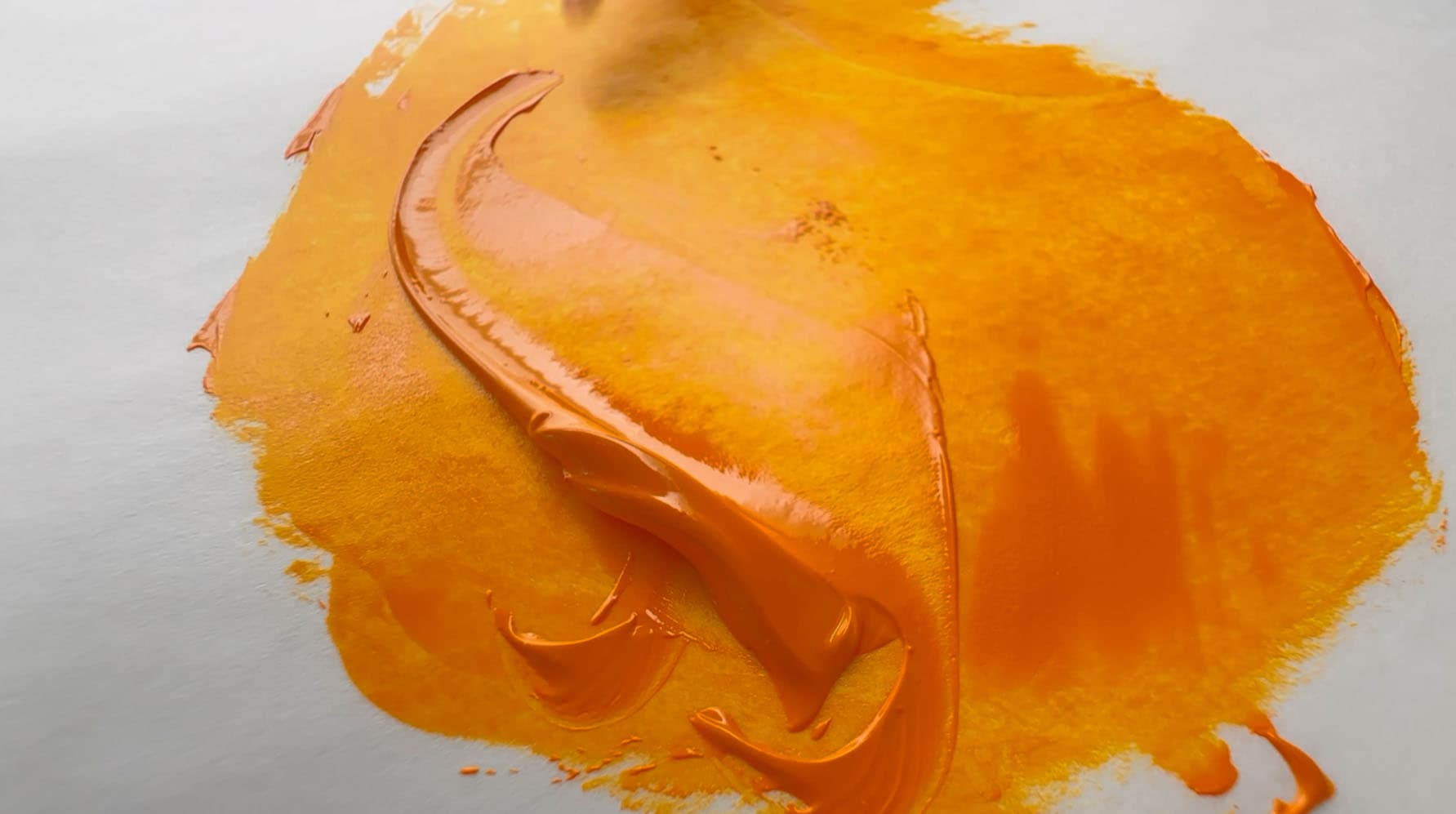 A daub of transparent yellow-orange oil paint